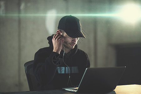 年轻有才华的黑客在暗办公室工作时使用笔记本电脑危险安全程序员骇客商业数据犯罪网络刑事男人图片