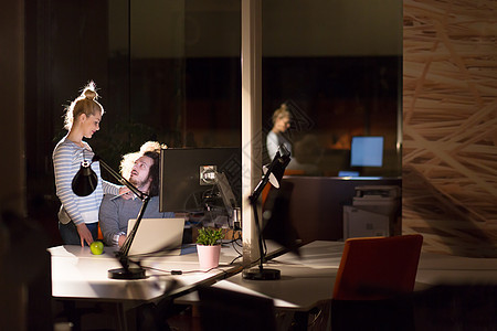 夜间办公室的年轻设计师电脑商业屏幕夫妻人士监视器笔记本女士男人员工图片