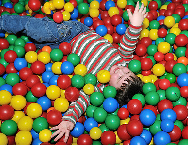 在多彩球中快乐的孩子玩具享受蓝色中心按钮剪贴塑料紫色水池游戏图片
