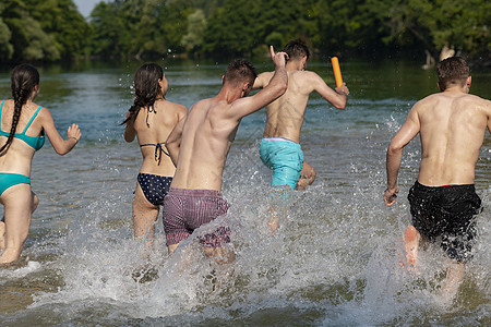 一群快乐的朋友在河边玩乐旅行青少年喜悦跑步朋友们游泳衣游泳团体海滩闲暇图片
