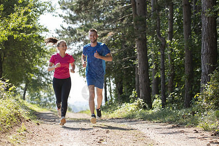 夫妻在乡村路上慢跑时享受健康的生活方式 在农村公路上游骑竞赛训练女士森林赛跑者女孩公园男人日光晴天图片