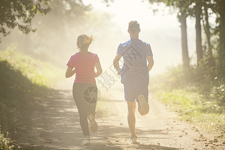 夫妻在乡村路上慢跑时享受健康的生活方式 在农村公路上游骑女士日光公园男人赛跑者日落行动女性女孩森林图片