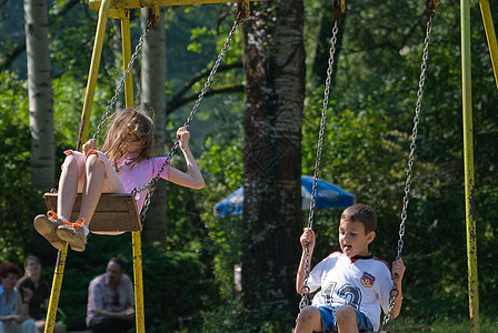 快乐的少女挥摆游戏操场太阳家庭公园享受快感乐趣女孩冒险图片
