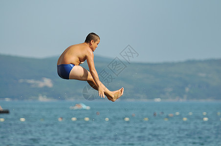 男孩跳海空气热带技巧波浪游泳喜悦旅行孩子天空游泳者图片