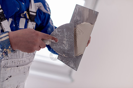 建筑工人在石膏墙上贴石膏墙壁泥水匠工人维修材料男人承包商水泥男性房间图片