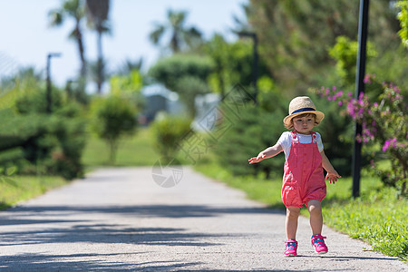 小女孩奔跑小女孩在夏天公园跑来跑去帽子孩子乐趣幼儿园女孩姐姐童年跑步团队微笑背景