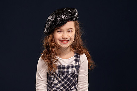 时髦的黑发小子在演播室表演 黑人背景 儿童时尚工作室女学生帽子头发冒充女孩青少年裙子乐趣衬衫图片