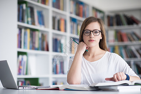 图书馆女生在学校图书馆学习的女生人数技术电脑知识眼镜青少年女孩成人女士研究桌子背景