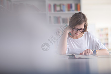 图书馆女生在学校图书馆学习的女生人数桌子女士女性互联网女孩微笑大学书架青年学校背景