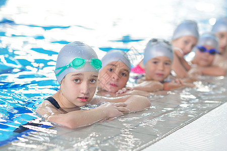 游泳池中儿童群体蓝色微笑女孩娱乐女性学习水池游泳者男性培训师图片
