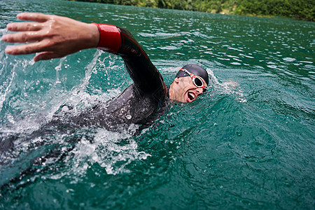 身穿湿衣在湖上游泳的三亚体运动员速度运动装力量潜水活力男性游泳者钢铁侠风镜男人图片