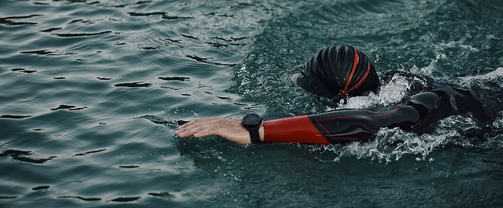 穿着湿衣服在日出湖上游泳的三亚体运动员竞赛锻炼活力风镜男人耐力行动潜水铁人运动图片