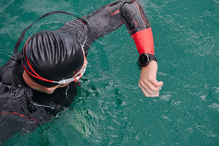 在湖布置智能观察上游泳的三亚体运动员手表运动装力量耐力全球定位行动速度铁人运动图片