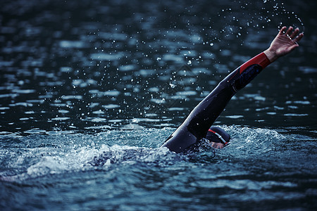 穿着湿衣服在日出湖上游泳的三亚体运动员运动装风镜日落游泳衣铁人运动游泳者行动潜水男性图片