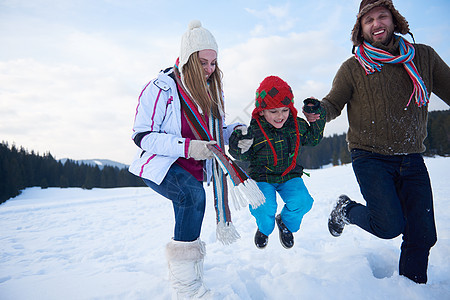 寒冬在雪中玩在一起的幸福家庭男生女儿父亲乐趣母亲女士女孩男性假期公园图片