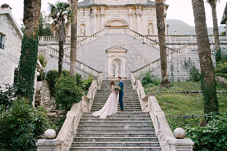 新新娘和新郎站在黑山普尔坎杰教堂花园的阶梯上图片
