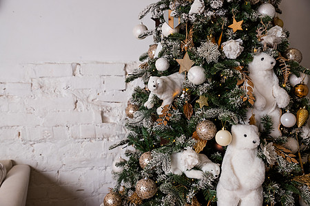 用球和玩具装饰的美丽大圣诞树 用丝带装饰的节日圣诞气氛礼物 用软玩具装饰的圣诞树 用北极熊装饰的树 舒适的内饰装饰品新年假期家居图片