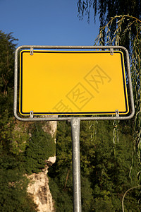 树木背景的黄色路标标志图片