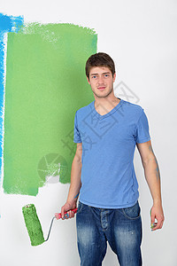 英俊的青年男子用彩色漆白白墙蓝色画家维修工人工匠房子房间乐趣微笑装潢图片