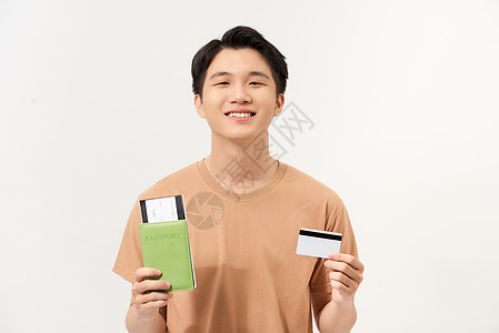 一个快乐的年轻男子的肖像 他持有护照和机票 显示塑料信用卡与世隔绝图片