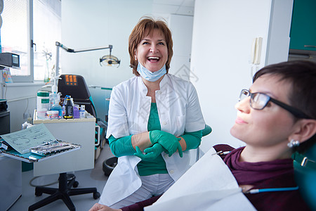 医生关心病人牙医病人中的妇女女士牙科椅子从业者女性助手治疗女孩卫生员药品背景