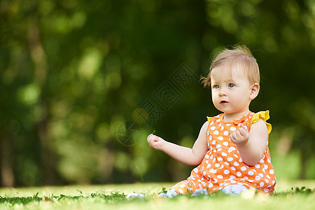 婴儿在公园中女孩晴天场地喜悦草地幸福乐趣微笑闲暇孩子图片
