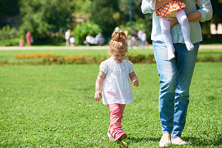 小女孩在公园玩得开心女性叶子草地婴儿快乐乐趣女儿童年花园喜悦图片