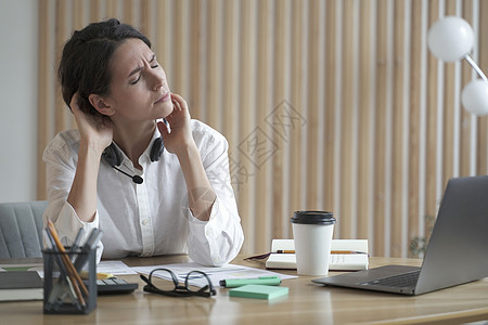 工作超负荷的远程呼叫中心操作员女士疲劳和颈部疼痛图片