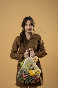 “零废物”概念 年轻的黑发妇女拿着有机水果和蔬菜的网状生态袋 用可重复使用的编织网包购买杂货图片