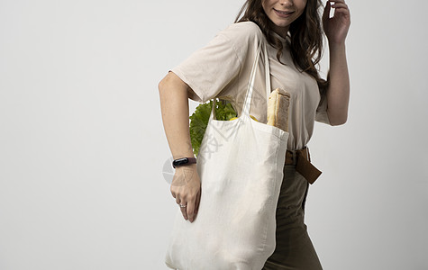 女人拿着装有蔬菜的纺织杂货袋 零废物概念 无包食品购物 有机水果和蔬菜的环保天然袋帆布杂货店食物小样女士店铺生态女性环境市场图片