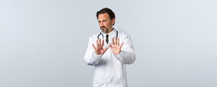 Covid-19 冠状病毒爆发 保健工作者和大流行病概念 穿着白色大衣的男医生愤怒地说不 表现出拒绝姿态 叫停或离家出走图片