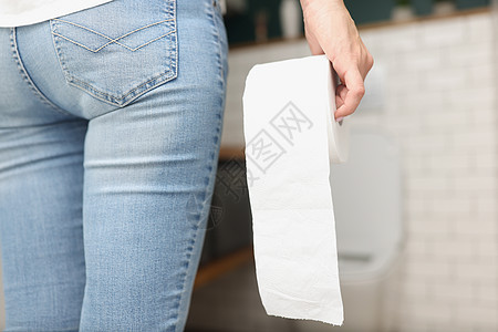 妇女手握着卫生纸卷在手 来到厕所房间便秘身体洗手间毛巾浴室腹泻装修裁剪卫生卫生间图片