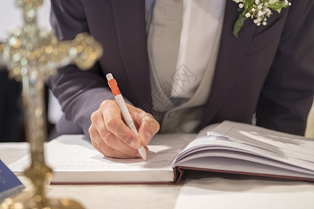 新郎在天主教婚礼上的签名登记簿上签字新娘新婚社交派对白色婚姻结婚日夫妇情绪裙子图片