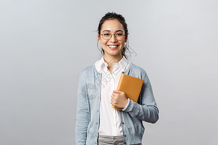 教育 教师 大学和学校的概念 戴眼镜的年轻微笑女性 雇主或学生 拿着计划表 在笔记本上写下商务会议 准备日程日记职业自由职业者女图片