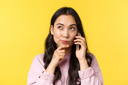 人们的情绪 生活方式 休闲和美丽概念 深思可爱的亚洲女孩在打电话 书桌或从外卖点食物时思考 将左上角看成是做选择图片