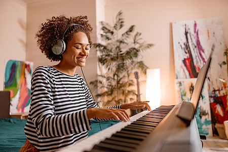 在家玩合成器的快乐年轻女子成人作曲家作者女性音乐家音乐演员玩家天赋钢琴家图片
