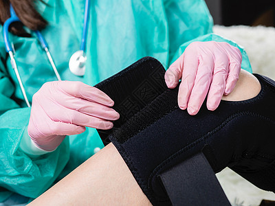 理疗师帮助一名女性在腿部手术后戴上牙套 医生的手贴近了伤口疼痛诊所运动训练身体事故骨头绷带培训师创伤图片