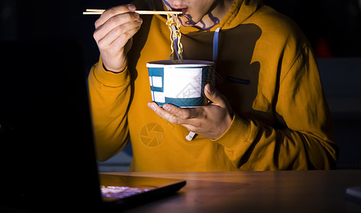 男人在吃面和看电影学生工作盘子技术自由职业者手表食物桌子电影拉面图片