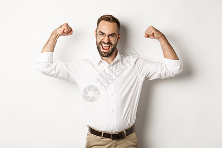 成功的经理柔力二冰棒 显示肌肉和自信 站立在白色背景上购物工作室工作衬衫金融办公室商务男人标识手势图片