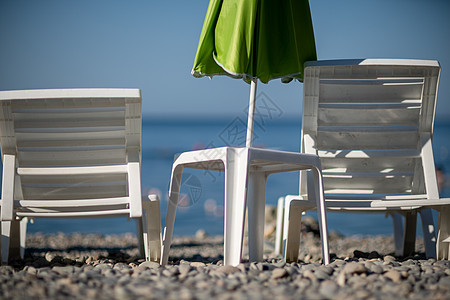 几个白太阳休息员和一只雨伞 在荒凉的海滩上 完美的假期概念闲暇海岸蜜月蓝色天空天堂海洋躺椅旅行热带图片