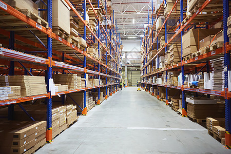 拥有高架货架和装货机的大型分配仓库架子建筑盒子托盘货物工人加载出口库存商业图片