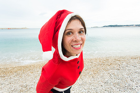 圣诞节和假日概念 — 海背景下身着圣诞老人套装的女性特写图片