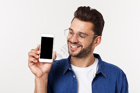 年轻人展示他崭新的智能手机 在白色的孤立屏幕男性推介会快乐技术商业微笑工作室相机时尚图片