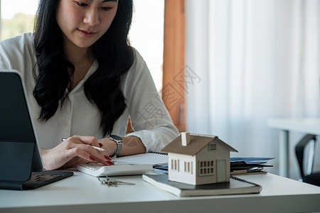 买卖房屋和房地产价格概念 女人使用计算器计算租金 金钱或家庭保险费用 计算抵押贷款 贷款或投资硬币经纪人现金银行业财富储蓄抵押商图片