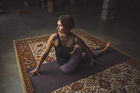 Yogi 女性在复古客厅的垫子上练习瑜伽姿势 运动 运动锻炼风格 家庭健身 健康生活方式 特写图片