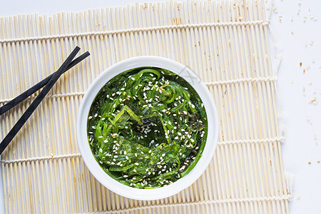 白碗中的瓦卡梅海鲜叶子饮食海藻芝麻蔬菜寿司藻类植物盘子背景