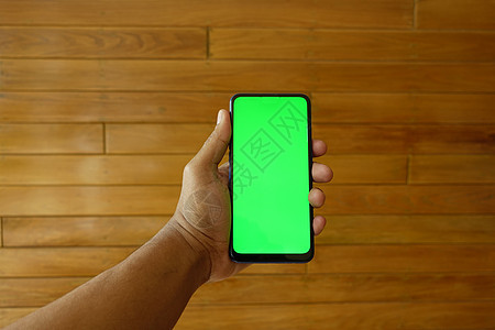 使用绿色屏幕智能手机近距离接近年轻男子的手电子触摸屏消息展示工具短信社会电话机动性手指背景图片