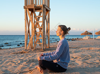 年轻健康的女人 在日出时在海滩上做瑜伽女性活力海洋沉思日落女士天空冥想姿势生活图片