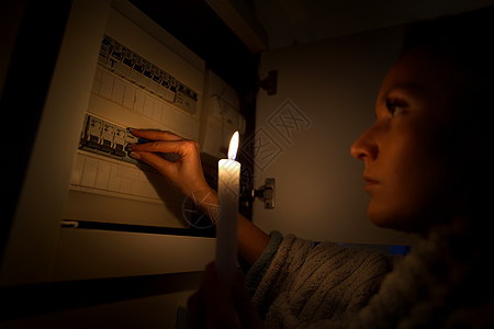 在停电或停电期间 在完全黑暗中调查家中保险丝盒的妇女 没有电的概念图片
