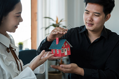 亚洲夫妇正在用手保护房地产投资者 租赁保险 买卖合同和维护中手势使用的概念图片